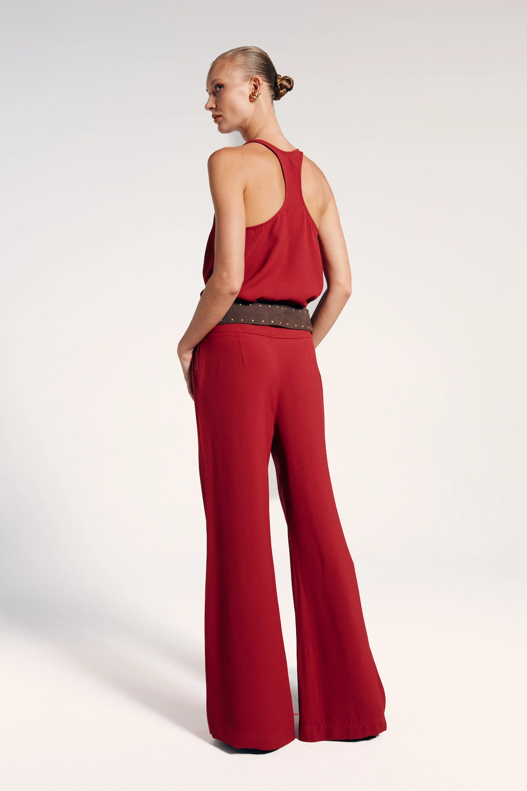 Modelo de calça alfaiataria vermelha, destacando-se pela elegância modernizada. Ideal para eventos formais ou combinações casuais mais ousadas.