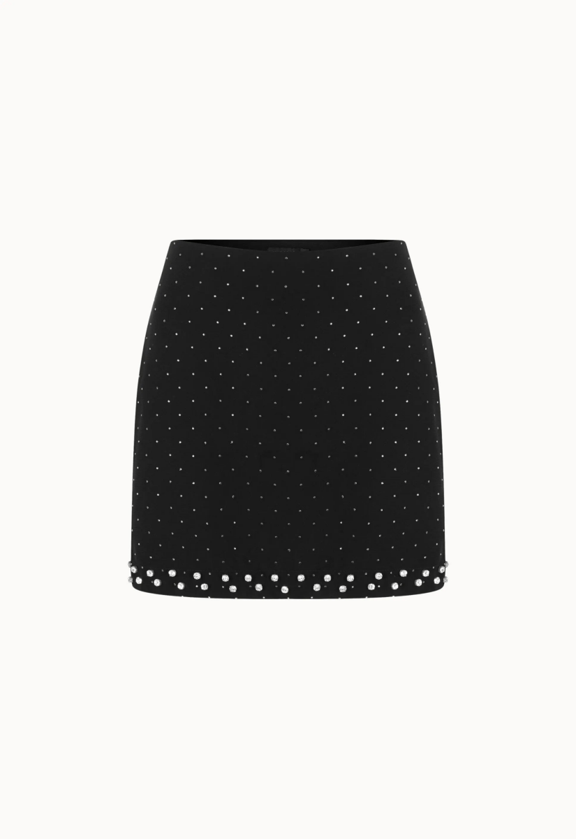 Mini saia com brilho decorada com tachas prateadas. O fundo branco destaca a elegância da peça.