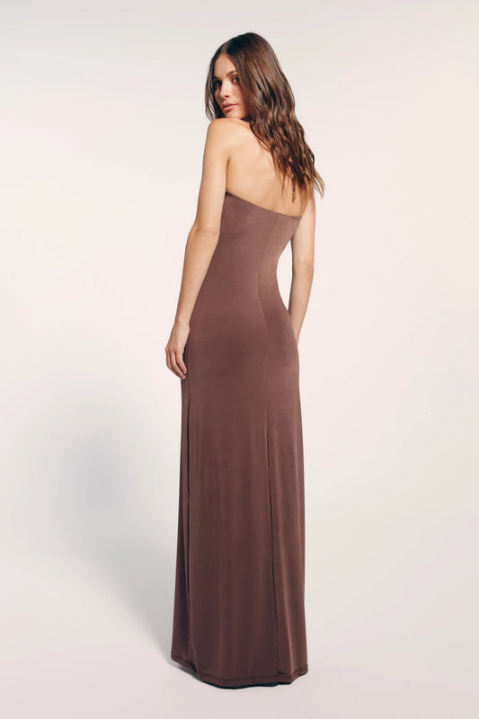 Vestido longo marrom visto por trás, a peça possui costas abertas.