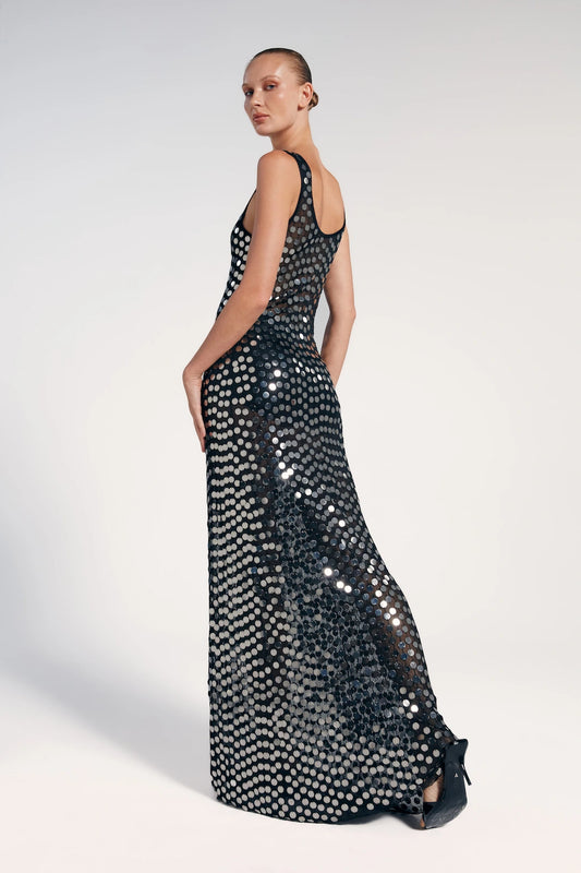 Vestido longo paetê preto visto de costas, modelo o combina como mini salto preto.