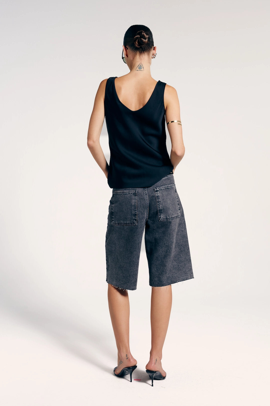 Bermuda jeans reta estonada vista de trás, ideal para um look casual e moderno.