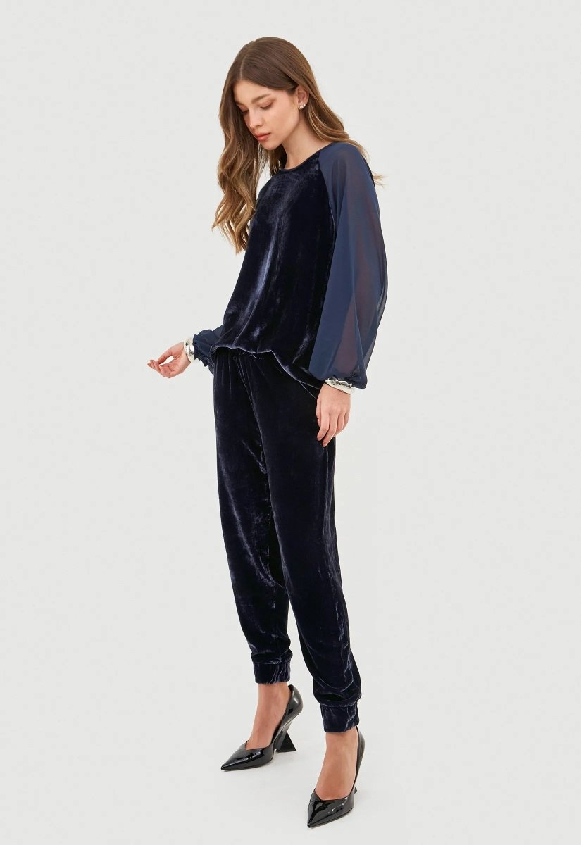 Calça feminina em veludo azul com detalhe de elástico na barra.