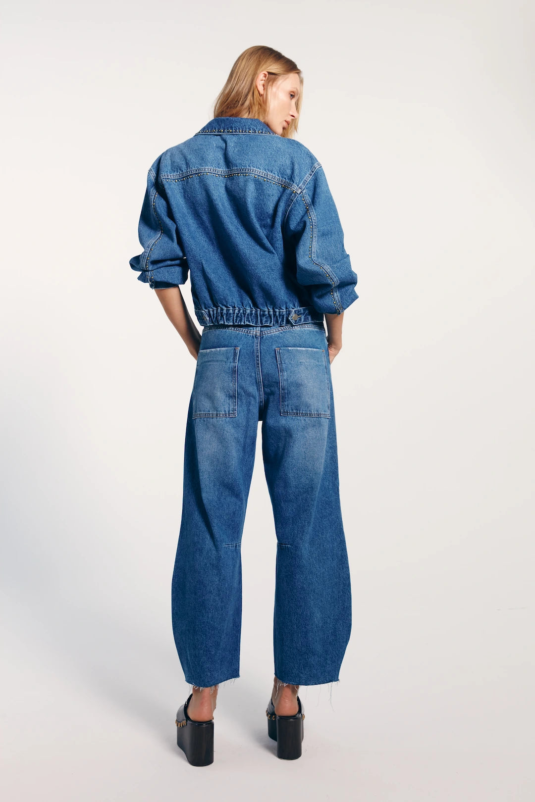 Calça jeans barrel vista de trás, o look é moderno e despojado, perfeito para um visual casual e confortável.