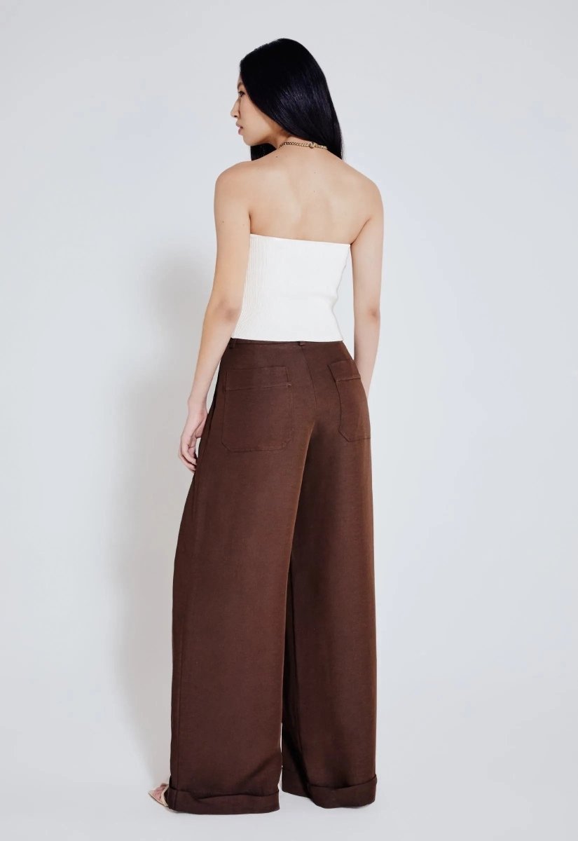 Calça marrom wide leg vista de trás, elegante e solta, com dois bolsos traseiros.