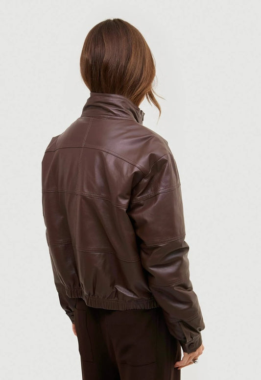 Jaqueta bomber marrom com acabamento brilhante, estilo casual. Possui gola alta e fechamento com botões, ideal para compor looks elegantes e modernos.