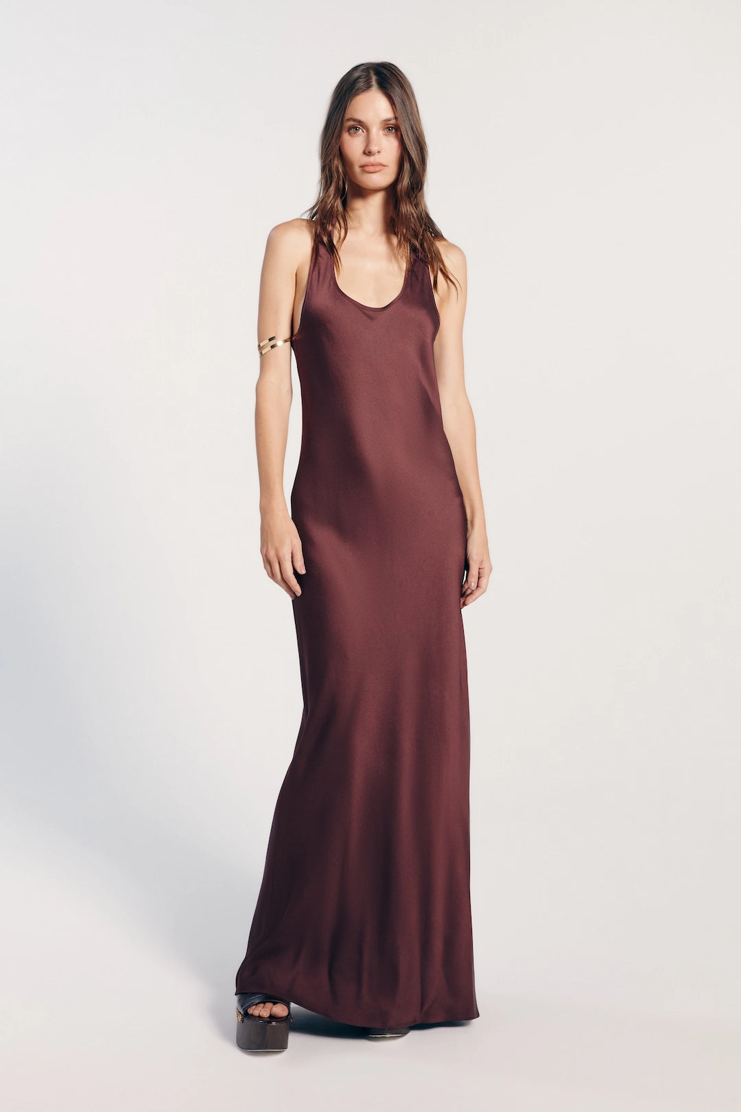 Vestido longo marrom, elegante e sofisticado, perfeito para eventos formais e ocasiões especiais, destacando-se pelo seu caimento fluido e cor clássica.