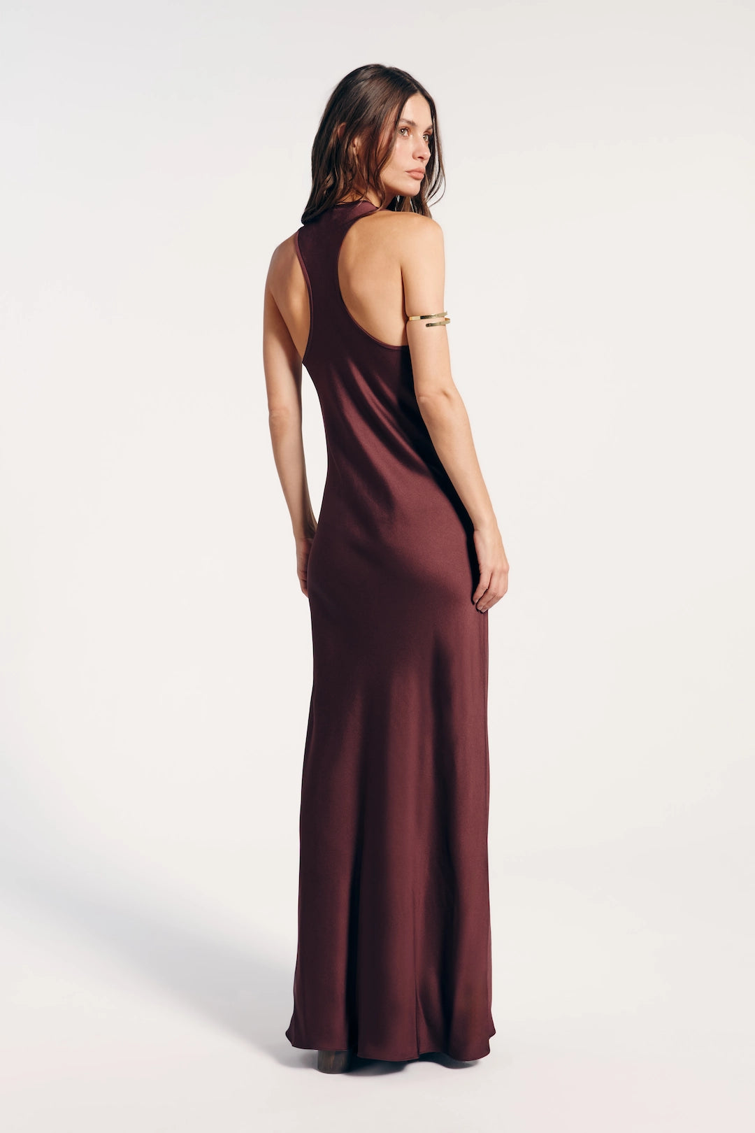 Vestido longo marrom visto de costas, destacando-se por sua elegância e versatilidade. Ideal para eventos formais ou ocasiões especiais.